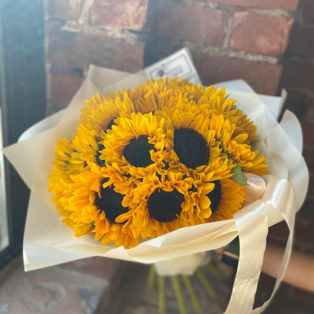 Букет из 19 подсолнухов в стильной упаковке 